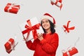 Girl in a red sweater and Santa Claus hat holding white giftbox with red ribbon Royalty Free Stock Photo