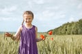 Girl with red tulip flowers posing in the wheat field, bright sun, beautiful summer landscape Royalty Free Stock Photo