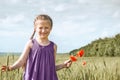 Girl with red tulip flowers posing in the wheat field, bright sun, beautiful summer landscape Royalty Free Stock Photo