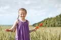 Girl with red tulip flowers posing in the wheat field, bright sun, beautiful summer landscape Royalty Free Stock Photo