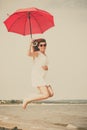 Girl with red umbrella on beach