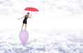 Girl with a red umbrella walking barefoot on a balloon flying in Royalty Free Stock Photo