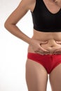 The girl in a red underwear to touch the fat on your stomach and Royalty Free Stock Photo