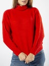 a girl in a red wool turtleneck and blue jeans on a white background