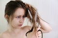 Girl regretfully cuts long hair with scissors