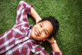 Girl, relax and lying on grass in backyard, resting and enjoying summer and nature outdoor. Children, smile and sunshine Royalty Free Stock Photo