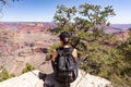 The girl relaxes on the edge of a rock overlooking the Grand Canyon in the USA and admires the view