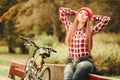 Girl relaxing in autumnal park with bicycle. Royalty Free Stock Photo