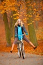 Girl relaxing in autumnal park with bicycle Royalty Free Stock Photo
