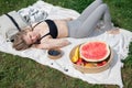 Girl relaxing and eat watermelon outdoor near lake. Picnic in nature