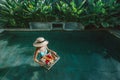 Girl relaxing and eating fruits in the pool on luxury villa in Bali Royalty Free Stock Photo