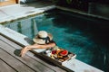 Girl relaxing and eating fruits in the pool on luxury villa in Bali Royalty Free Stock Photo