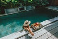 Girl relaxing and eating fruits in the pool on luxury villa in Bali Royalty Free Stock Photo