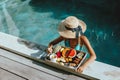 Girl relaxing and eating fruits in the pool on luxury villa in Bali Royalty Free Stock Photo