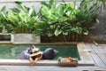 Girl relaxing and eating fruits in the pool on luxury villa in Bali Royalty Free Stock Photo