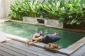 Girl relaxing and eating fruits in the pool on luxury villa in Bali Royalty Free Stock Photo