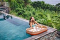 Girl eating floating breakfast in luxury infinity pool Royalty Free Stock Photo