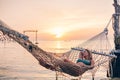 Girl relaxing in hammock on sunset beach Royalty Free Stock Photo