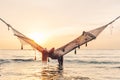 Girl relaxing in hammock on sunset beach Royalty Free Stock Photo