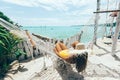 Girl relaxing in hammock in tropical beach cafe
