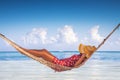 Girl relaxing in a hammock on tropical island beach. Summer vacation in Punta Cana, Dominican Republic