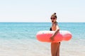 Girl relaxing with inflatable ring on the beach. shocked or surprised girl in the cold sea. Summer holidays and vacation concept Royalty Free Stock Photo