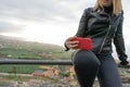 Girl relaxing sitting in fence on a viewpoint and cell phone in her legs. Curvy Teen sit in hilltop in silence and serenity