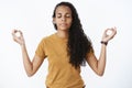 Girl releasing stress calming down before important meeting, meditating with closed eyes in lotus pose with raised hands Royalty Free Stock Photo