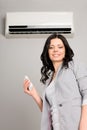 Girl with a remote control air conditioner Royalty Free Stock Photo