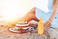 Girl resting on the beach, beautiful tanned legs against the blue sea, jar of cream Royalty Free Stock Photo