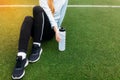 Girl resting after a good workout. Girl after exercise, drinking water on the football field. Portrait of beautiful girl in sports Royalty Free Stock Photo
