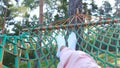Girl resting in a hammock in a pine forest.