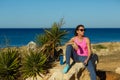 Girl resting after jogging on the rock at the sea Royalty Free Stock Photo