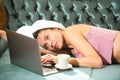 Girl resting and laying with laptop chatting online, drinking coffee in cozy sofa bed in the luxury bedroom an easy