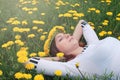 Girl resting on a sunny day in meadow of yellow dandelions Royalty Free Stock Photo
