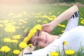 Girl resting on a sunny day in meadow of yellow dandelions Royalty Free Stock Photo