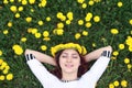 Girl resting on a sunny day in meadow of yellow dandelions Royalty Free Stock Photo