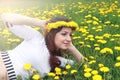 Girl resting on a sunny day in meadow of yellow dandelions Royalty Free Stock Photo