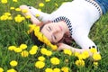 Girl resting on a sunny day in meadow of yellow dandelions Royalty Free Stock Photo