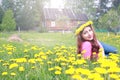 Girl resting on a sunny day in meadow of yellow dandelions Royalty Free Stock Photo