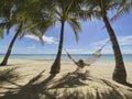 Girl resting on hammock in paradise resort.Beautiful beach with sea, palm trees