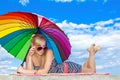 Girl in retro style by color umbrella on the beach