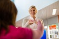 Girl returning book to librarian in library