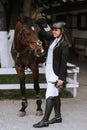 Girl rider adjusts saddle on her horse to take part in horse races Royalty Free Stock Photo