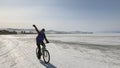 A girl rides a bicycle on the frozen snow-covered Lake Baikal