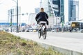 Girl rides a bike around the city, back view. Woman on a rented bike moves through the streets of Moscow