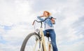 Girl rides bike sky background. Bike rental shops primarily serve people who do not have access to vehicle typically Royalty Free Stock Photo