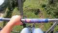 Girl rides or climbs on lift or cable car up mountain.