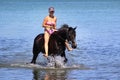 Girl rides a horse in the water.