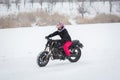 A girl rides a motorcycle on a frozen lake